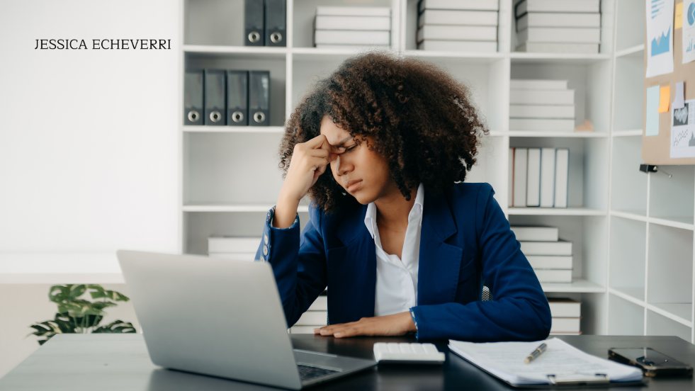 Business owner reviewing work on laptop with visible stress.