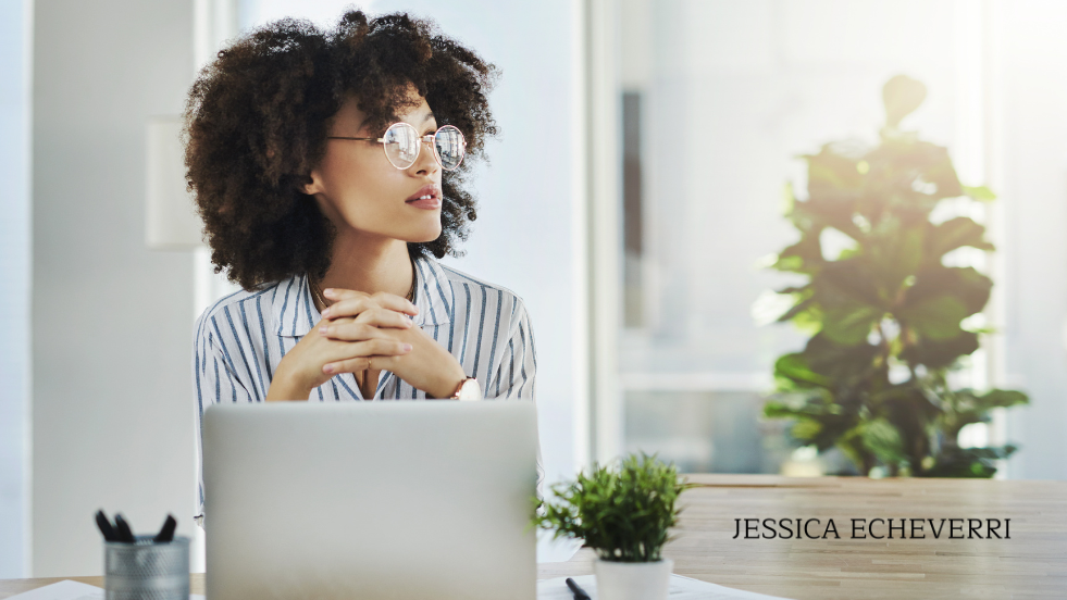 Professional woman reflecting thoughtfully at her desk.