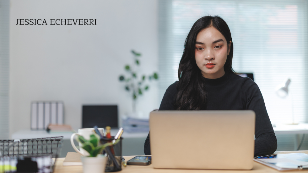 Business owner focused on work at laptop in modern office.