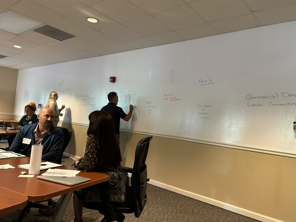 Business owners writing their quarterly wins on the GrowthCLUB Win Wall