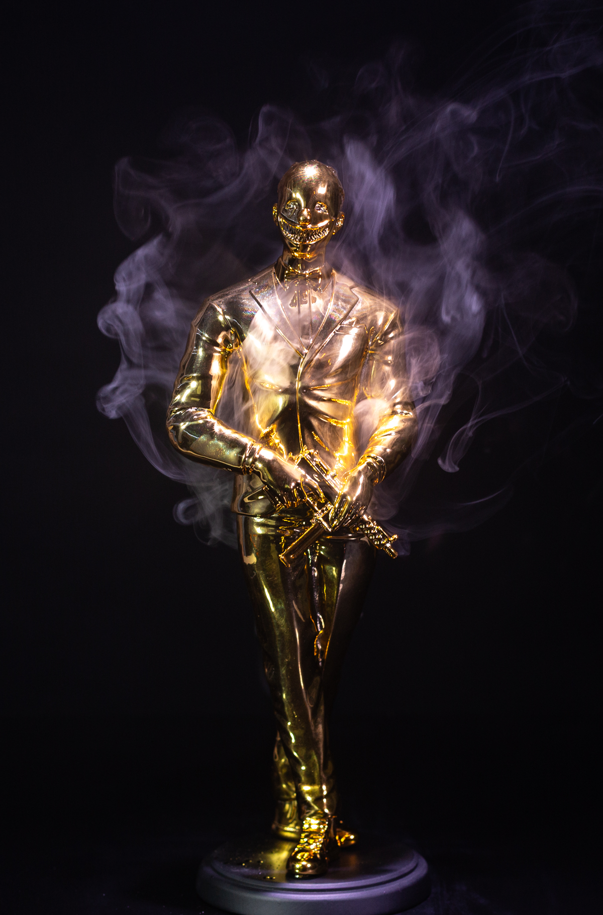 The Cuzzie, the GRRRD Awards trophy: a gold figure in a tuxedo wearing a grinning mask, wrapped in smoke