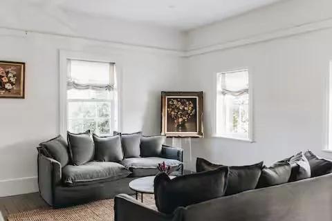 Bright lounge with grey sofas, white walls and a round coffee table