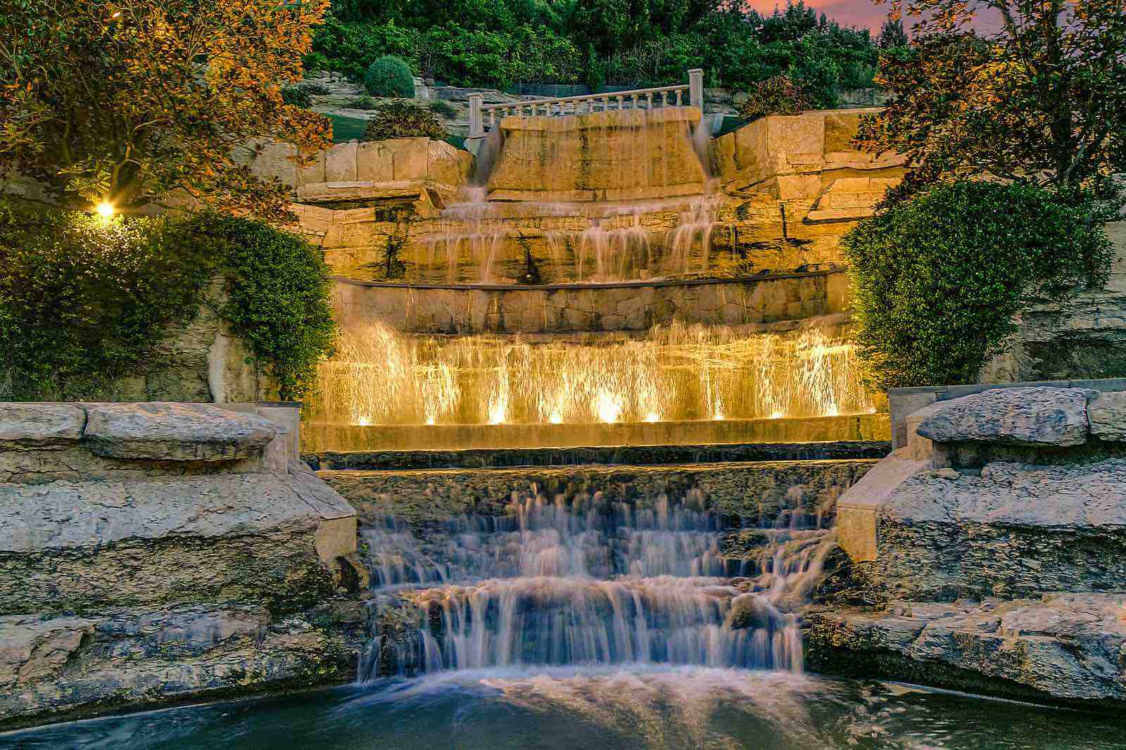 Illuminated water feature and hardscape lighting at dusk