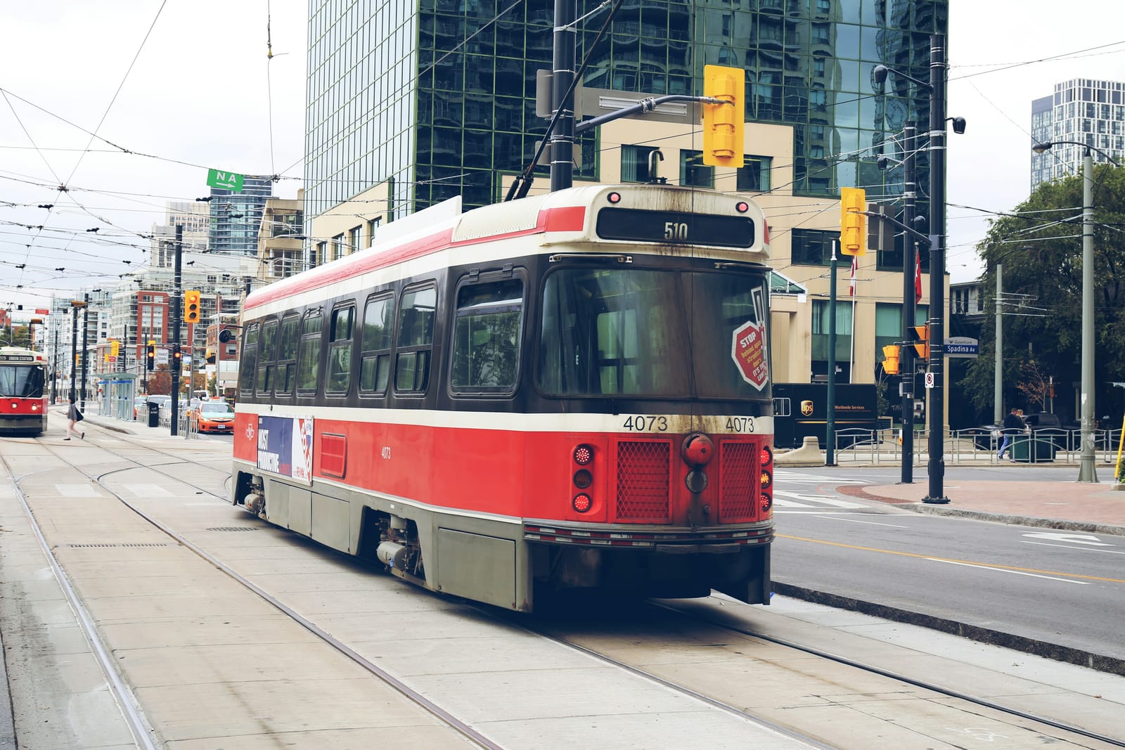 A red TTC streetcar on a downtown Toronto street