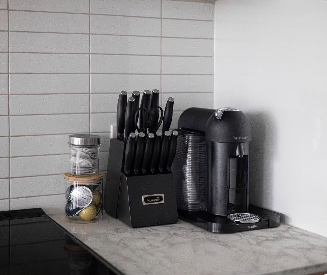 Nespresso machine, knife block and tea on the kitchen counter