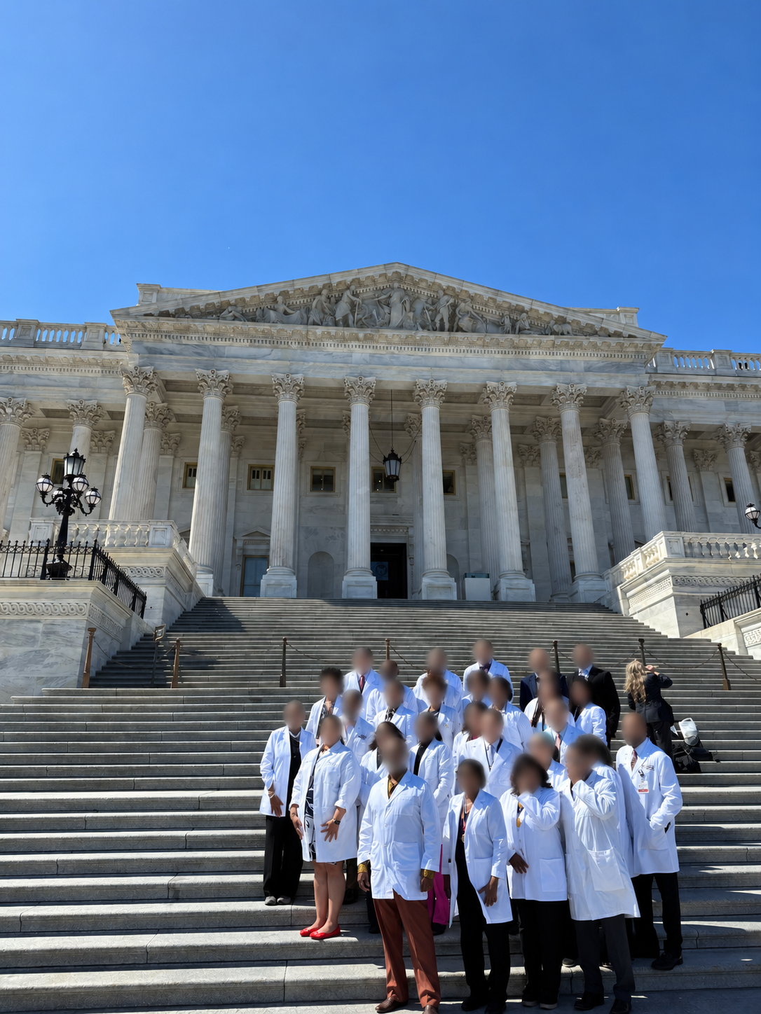 Physicians in white coats at the National Medical Association Colloquium, March 2025; faces obscured