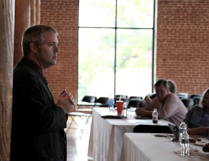 Keith Luscher speaking before a small group