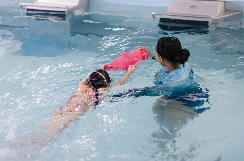 Intermediate swimmer practicing strokes with a coach