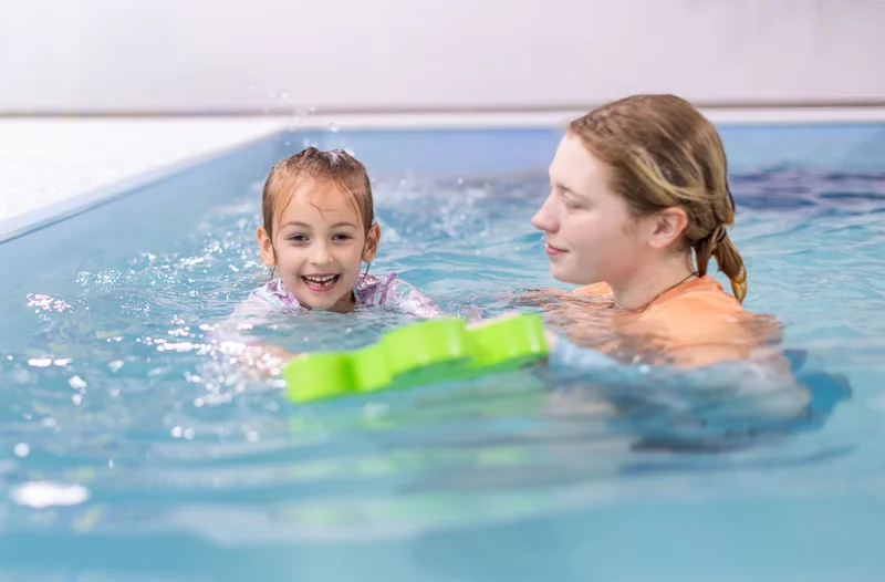 Beginner swimmer working with their instructor in the pool