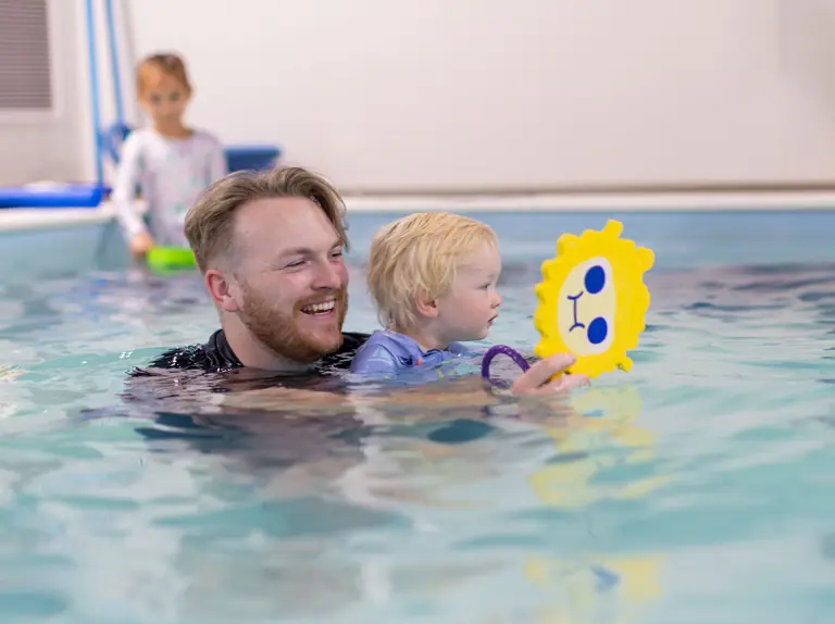 Center Lane coach laughing with a toddler during a lesson