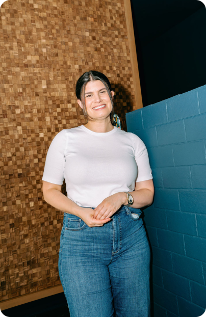 Rebecca smiling in front of a teal-tiled wall.