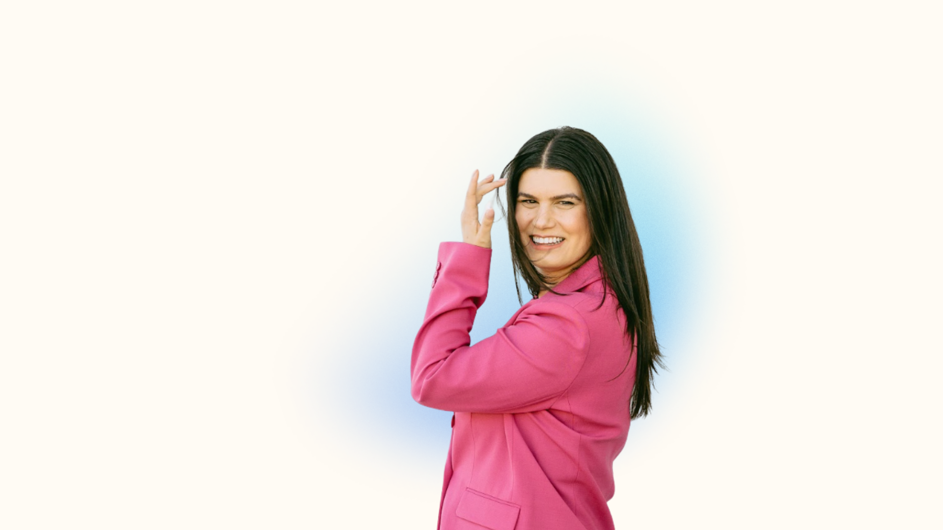 Rebecca Feinglos smiling over her shoulder in a pink blazer.