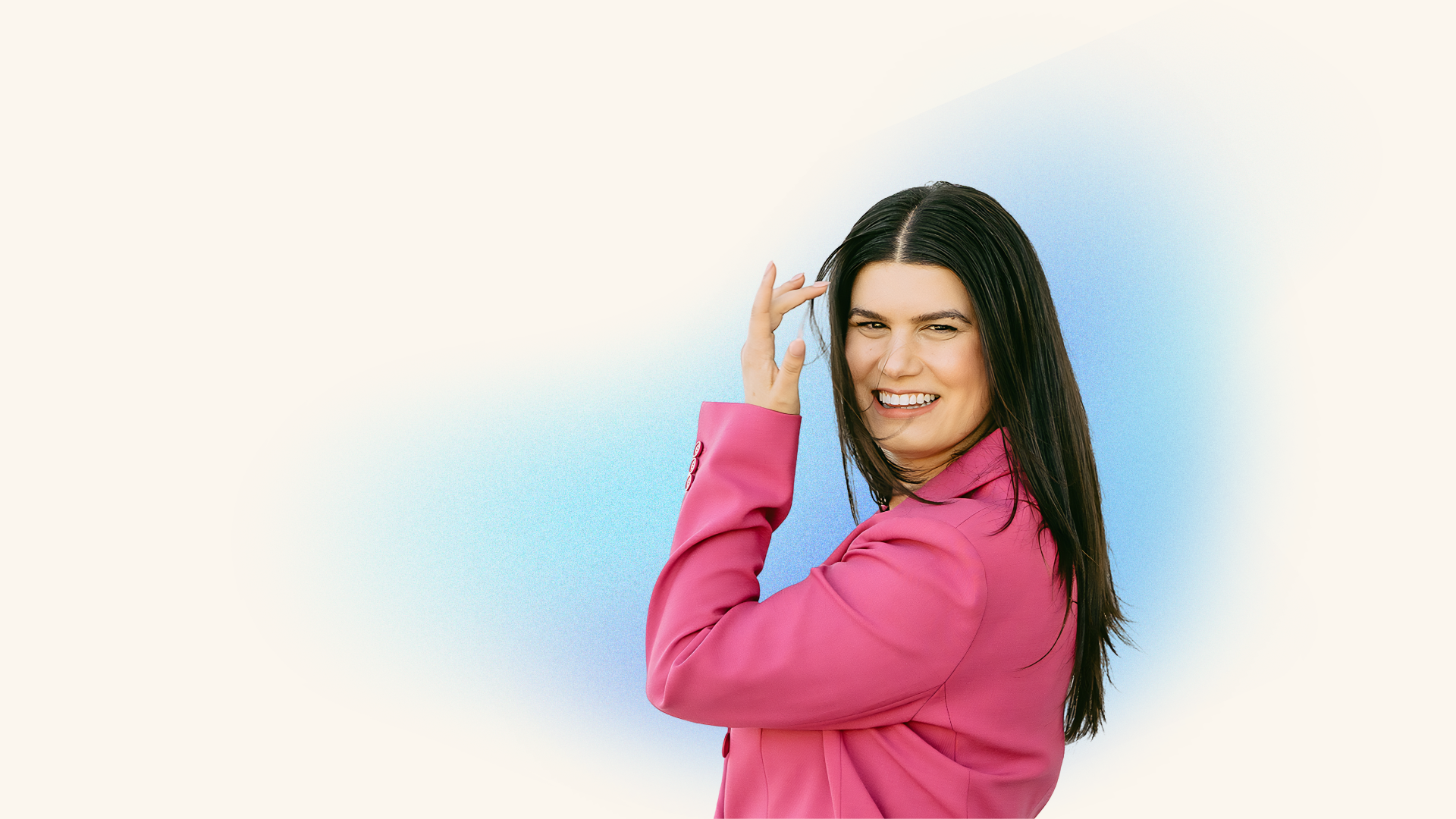 Rebecca Feinglos smiling over her shoulder in a pink blazer.