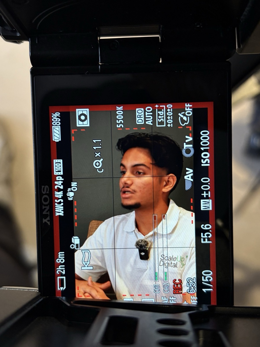 Omi from ScaleUp Digital recording a client testimonial, shot from an alternate camera angle