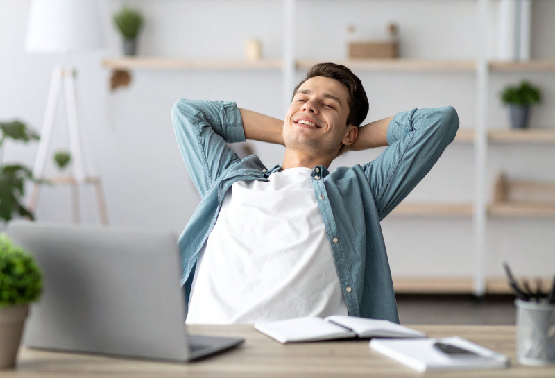Satisfied small business owner relaxing at desk after improving lead response time with automated systems.