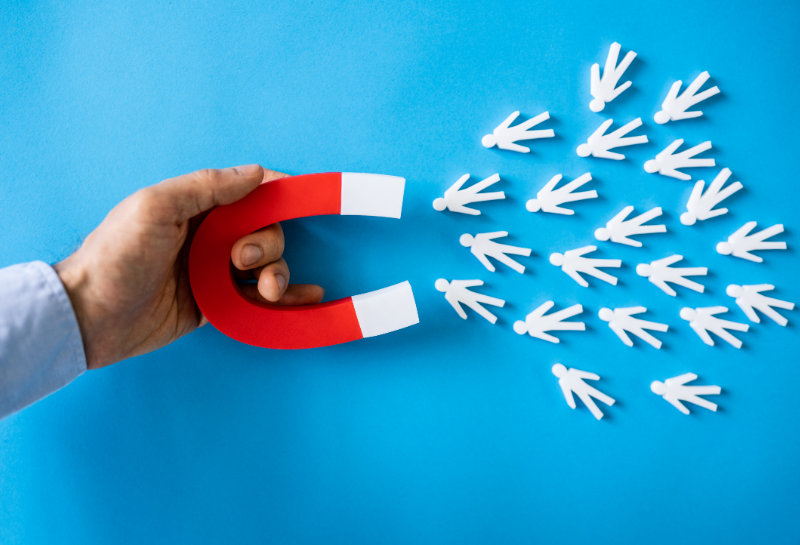 Magnet attracting multiple potential customers, representing lead generation and customer attraction in marketing.