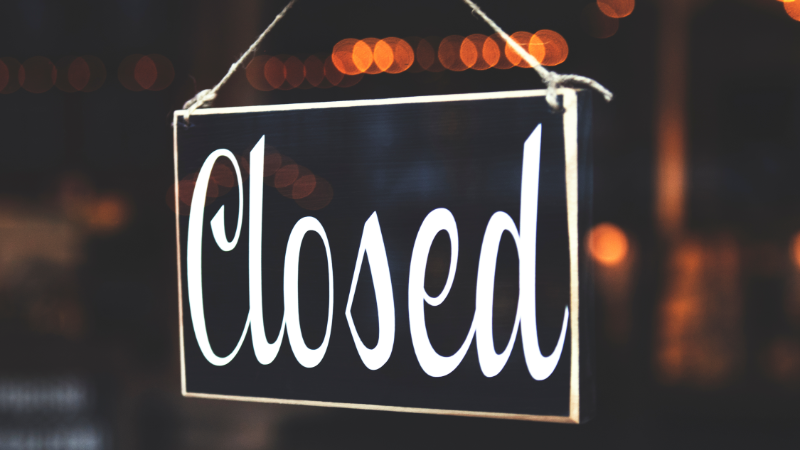 “Closed” sign hanging in a storefront window, representing missed business opportunities and lost customers due to lack of response or availability.