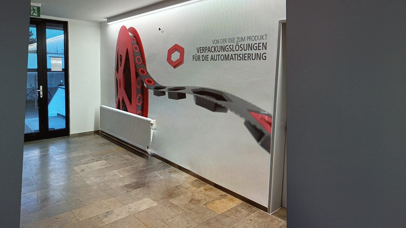 Wandgrafik mit Rothe-Logo, Spule und Schriftzug in einem Flur