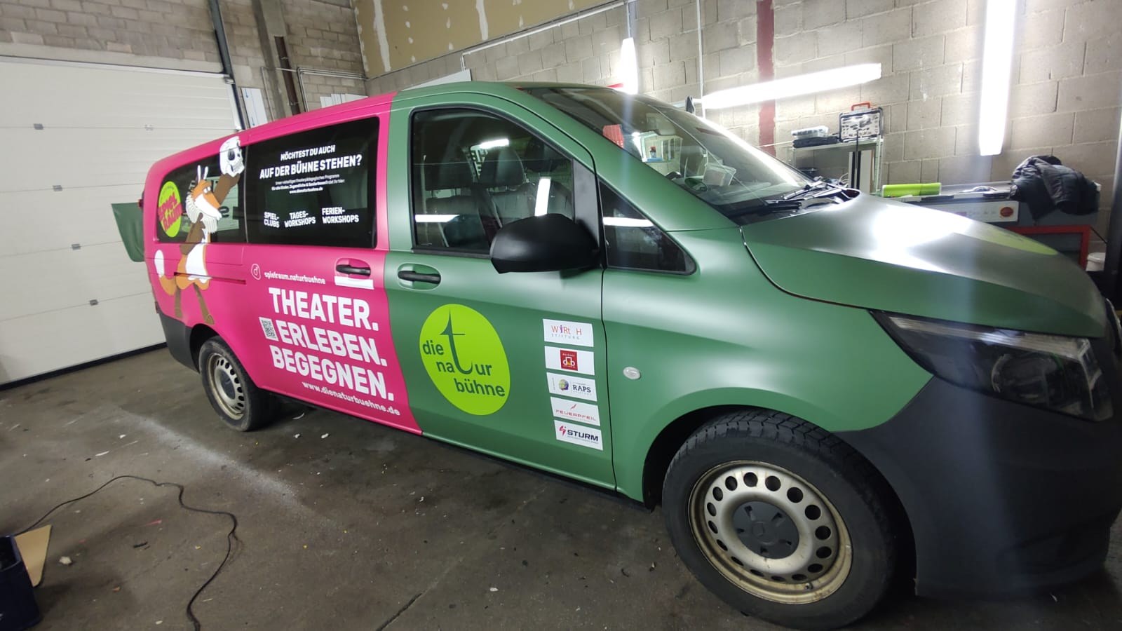 Transporter der Naturbühne mit pinker Fläche, Logo und Claim