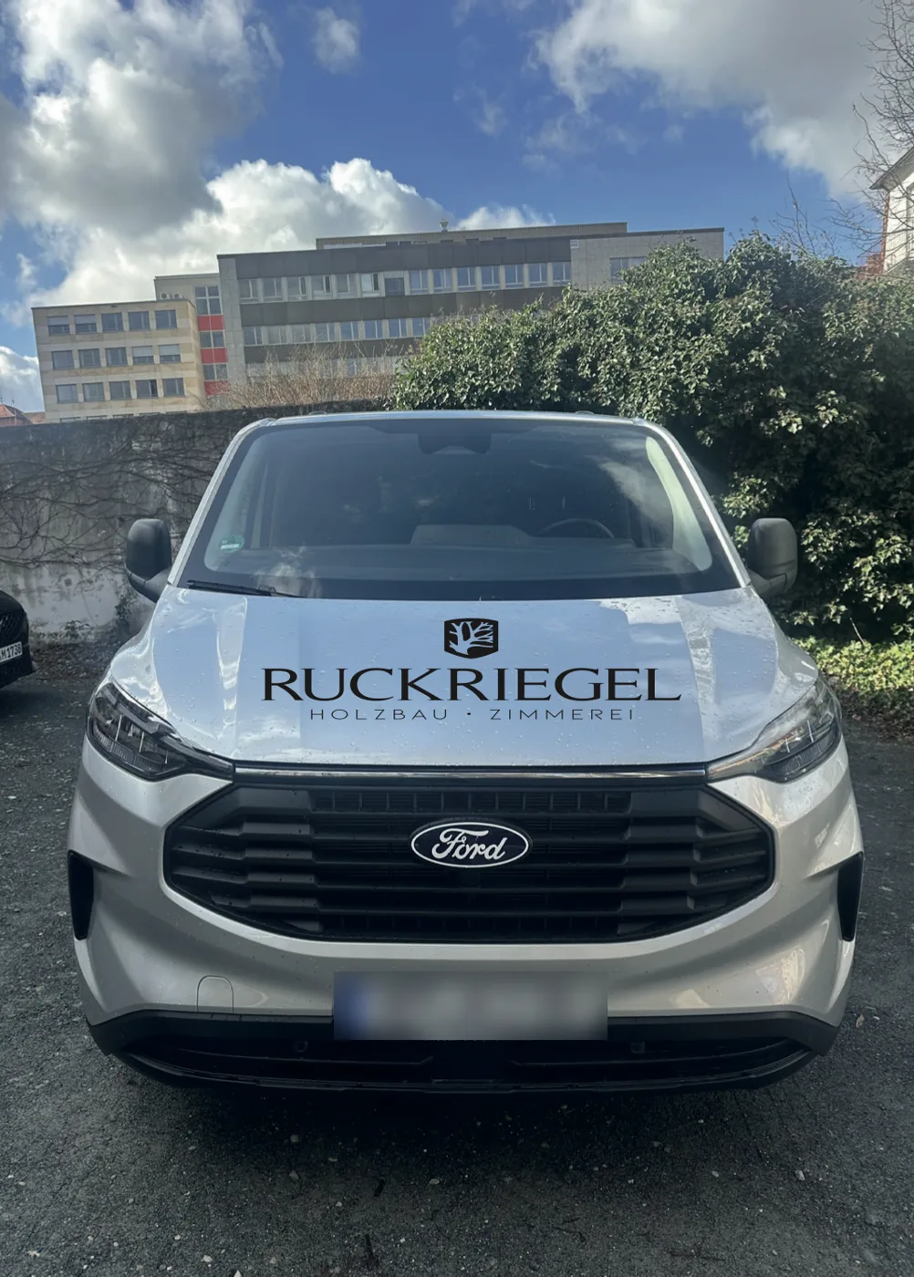 Ford Transit Custom von Ruckriegel Holzbau mit Logo auf der Motorhaube
