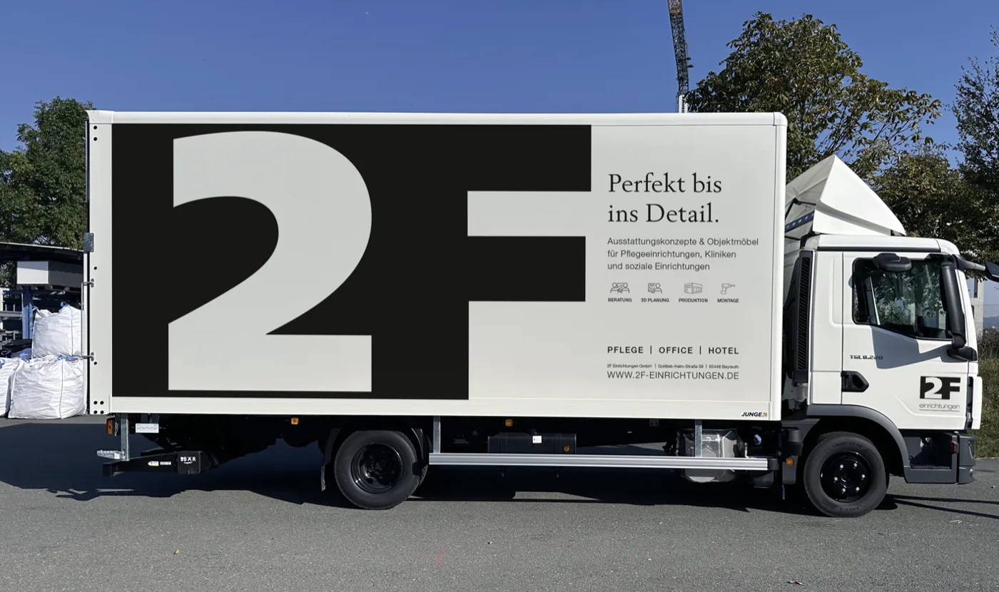 MAN-Lkw von 2F Einrichtungen mit großem 2F-Logo auf dem Koffer