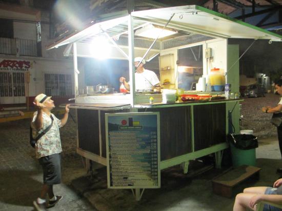 A man ordering food at a street taco stand in Puerto Vallarta Mexico.