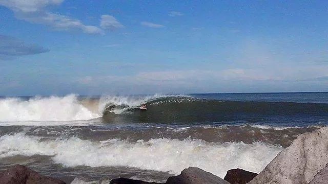 A surfer on a bif wave in the Bay of Banderas, Mexico.