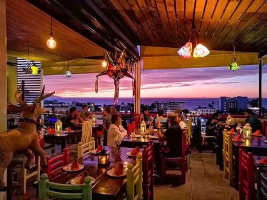 patrons gathered around tables a restaurant meños place in puerto vallarta