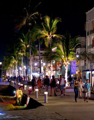 People walking on the malecon at night in Puerto Vallarta Mexico.