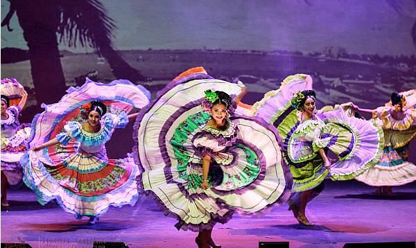 Mexican Women in colorful traditional dresses performing a traditional folk dance in Puerto Vallarta Mexico.