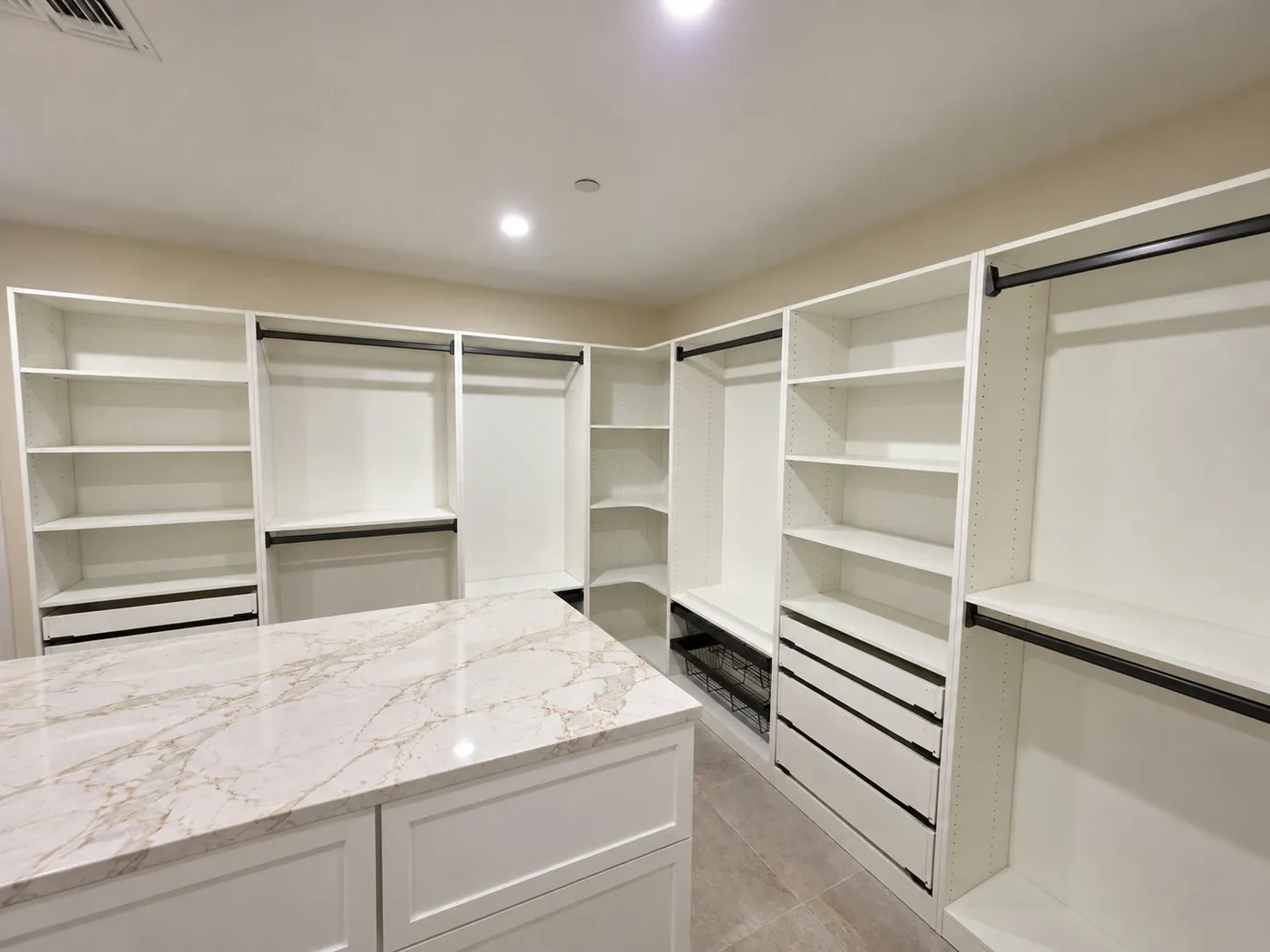 After: walk-in closet with custom cabinetry and a stone-top island