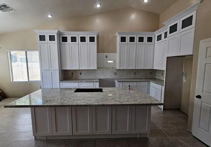 Glass-front upper cabinets beside a tall pantry