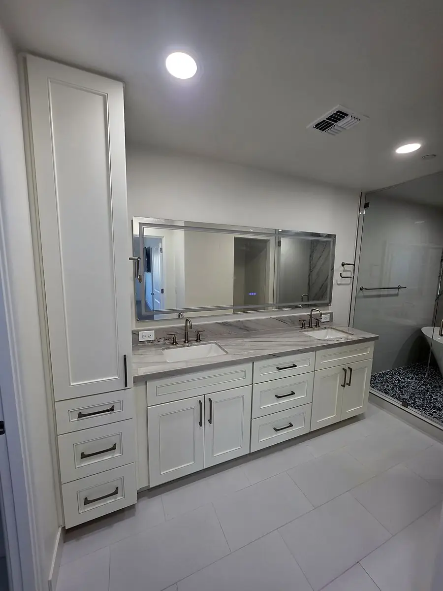 Double vanity with white shaker cabinets and a tall linen cabinet