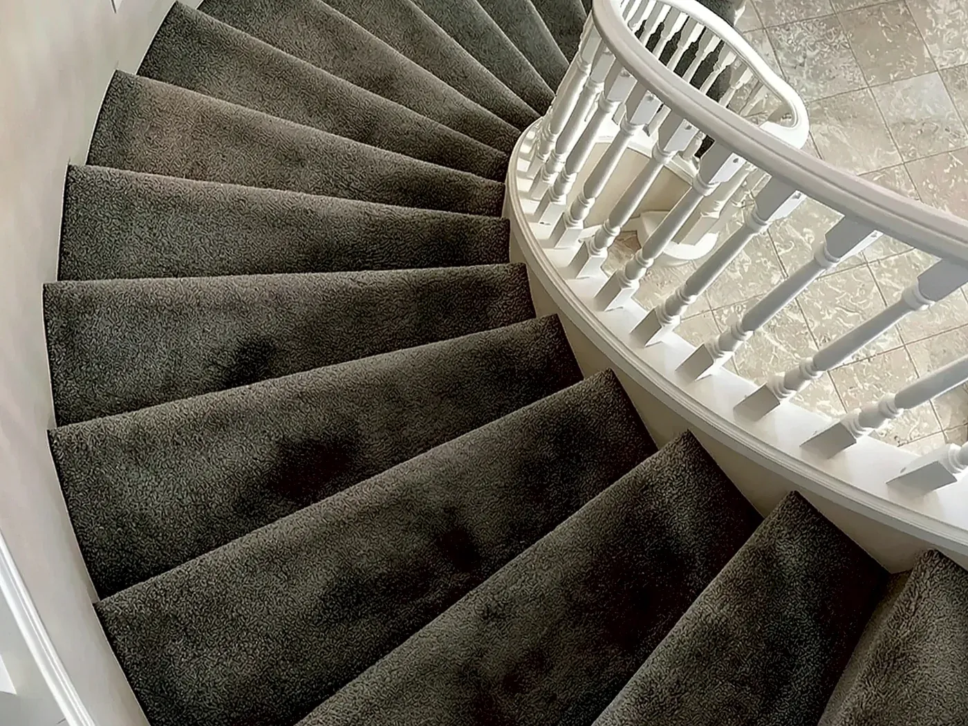 Before: curved staircase with worn carpet
