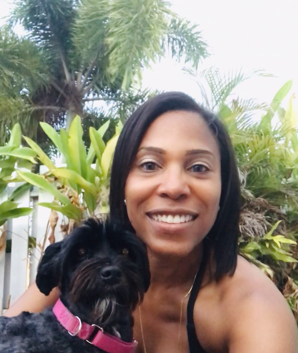 Coach T outdoors with a dog beside her.