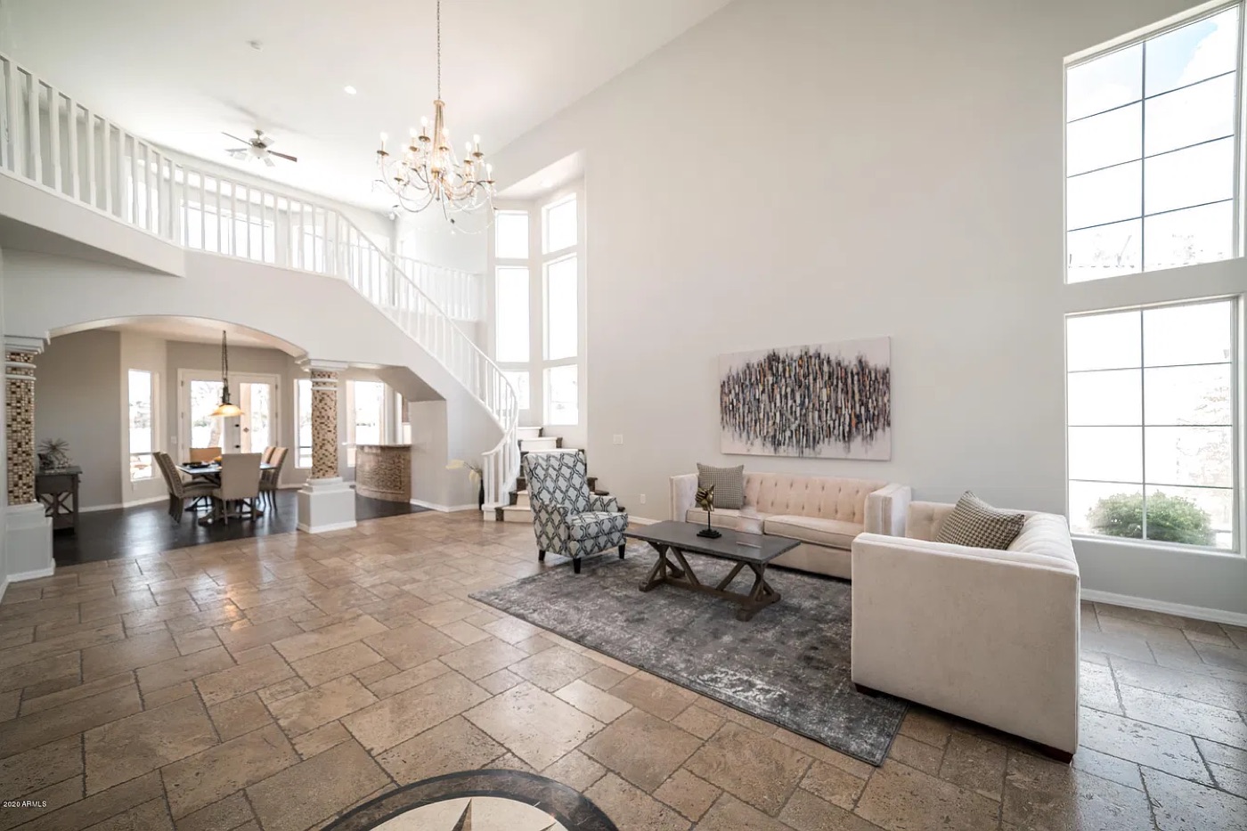 After: soft white walls, white stair railing, modern neutral furniture and a light rug