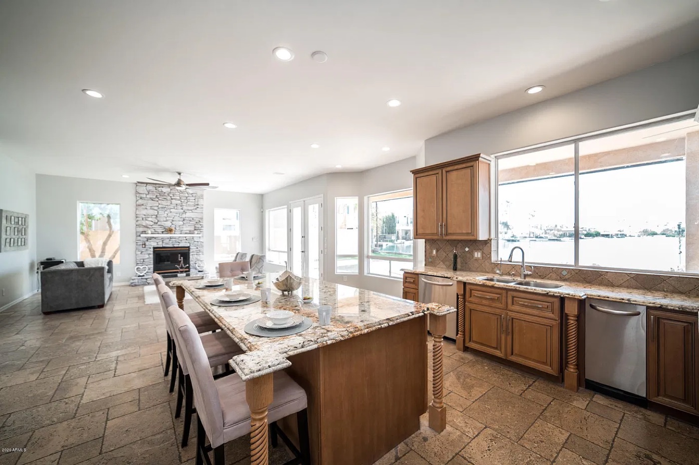After: light gray walls, whitewashed stone fireplace, neutral staging and a clear view of the water