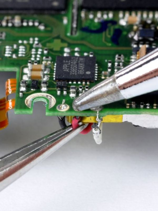 close up of a soldering iron and circuit board