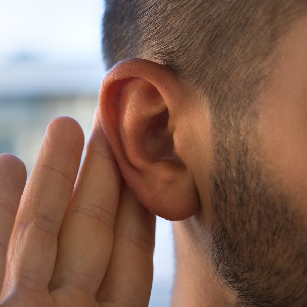 man holding his hand to his ear