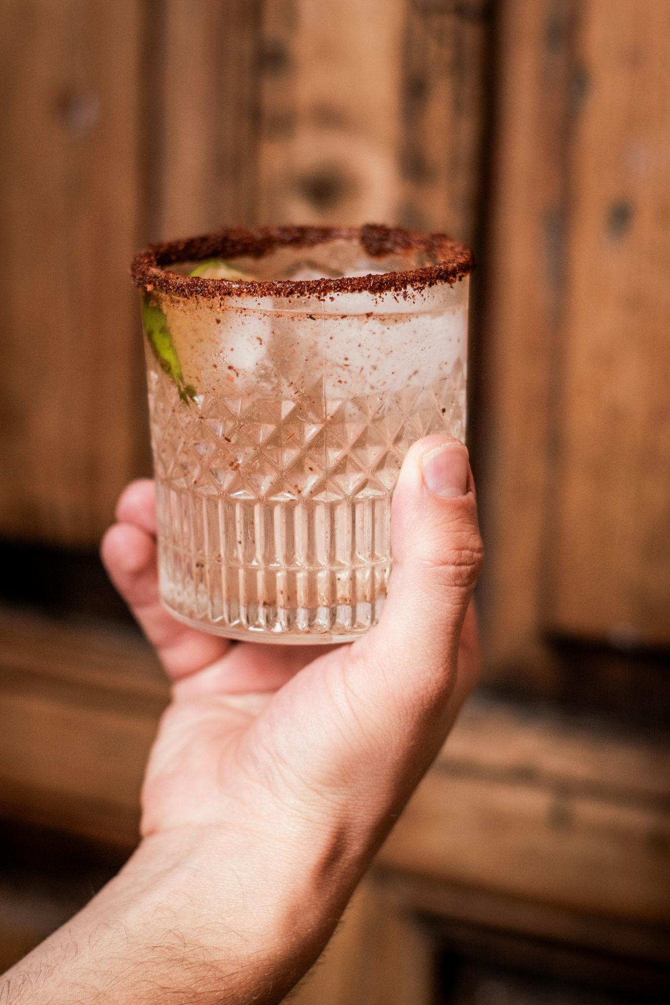 A red cocktail with a chile-salt rim
