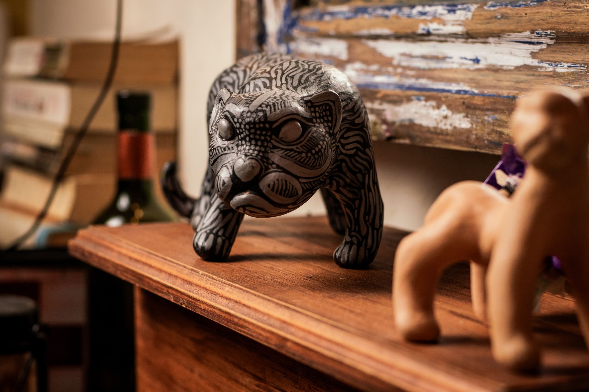 A black and white Amatenango ceramic jaguar on a wooden shelf in the bar