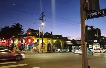 A dusk view of Silver Lake, California, showing a street corner with colorful murals