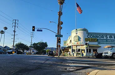 A view of the street in Eagle Rock, California, showing a corner building with a US flag