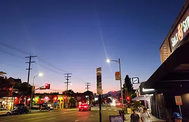 A wide-angle view of a street in Silver Lake at dusk, with streetlights and cars
