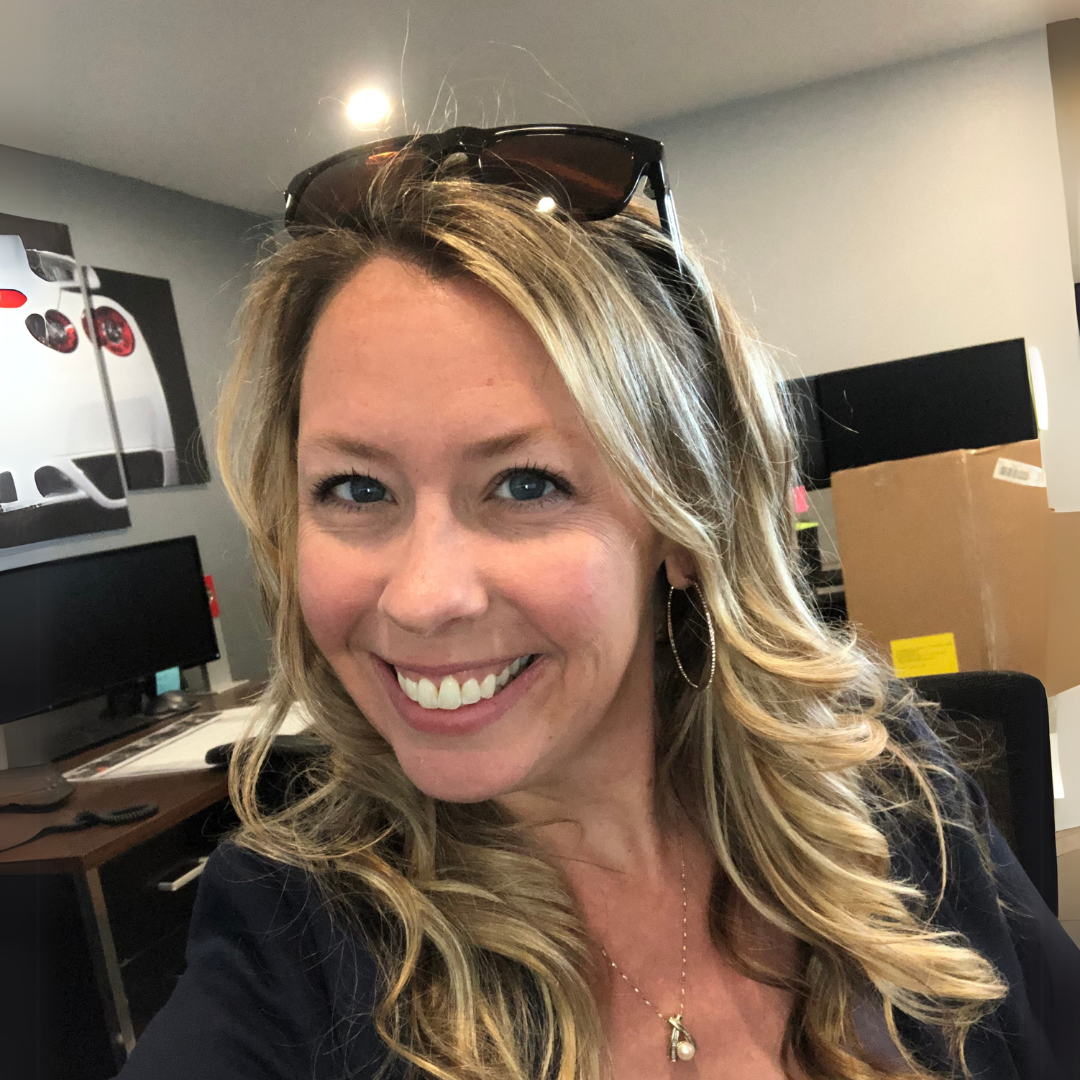Smiling woman with blonde hair sitting in an office.