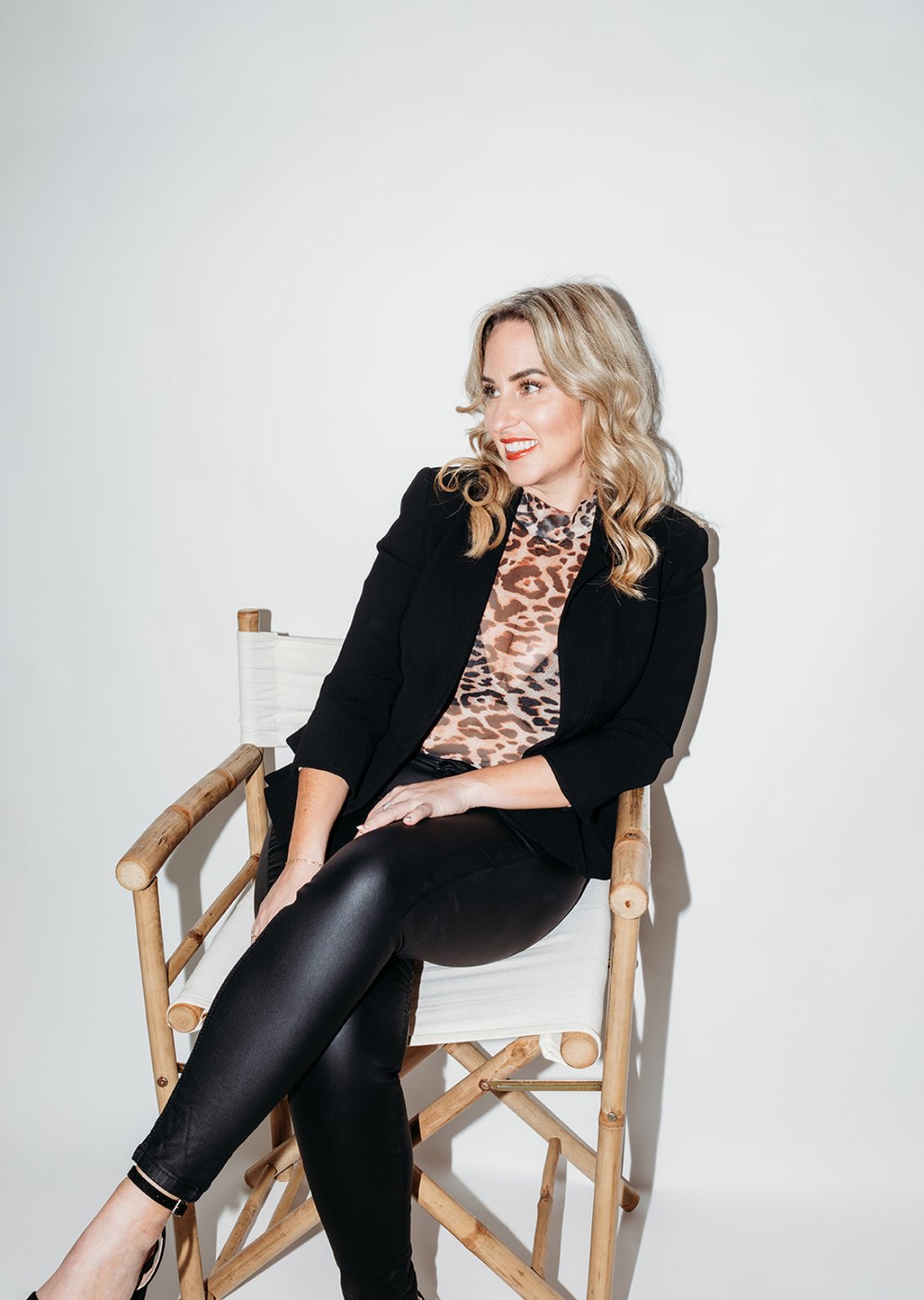 Gemma Heard in a black blazer, sitting on a director's chair