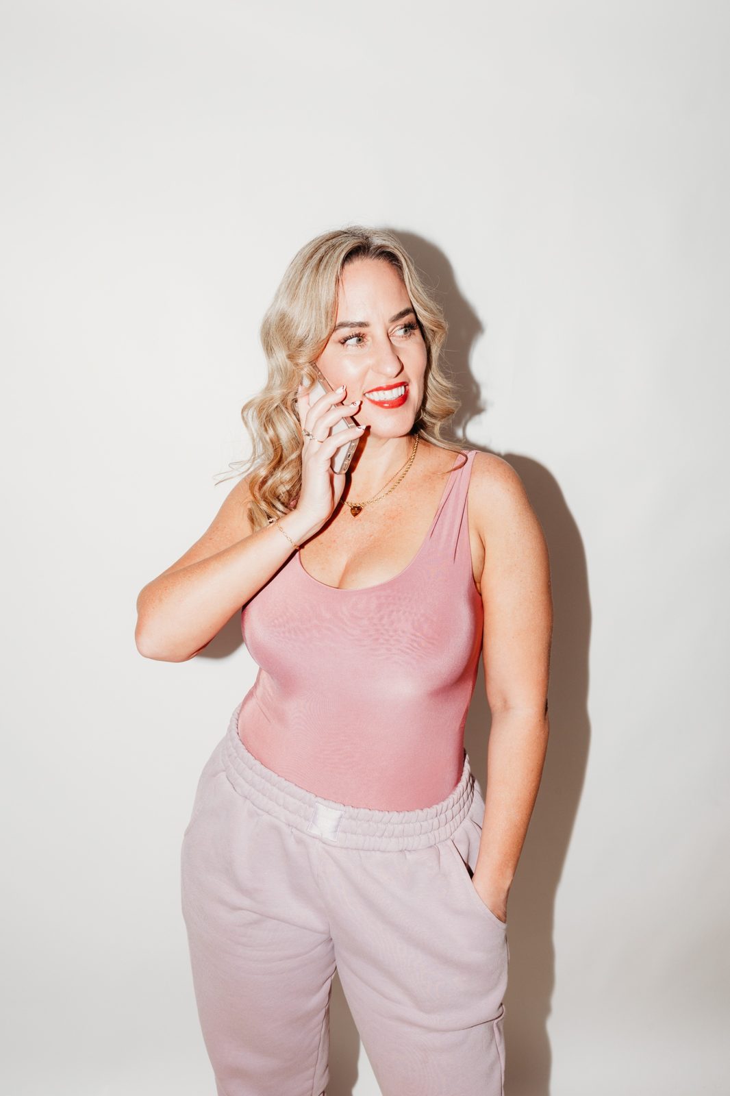 Gemma Heard in a pink top, smiling and talking on her phone