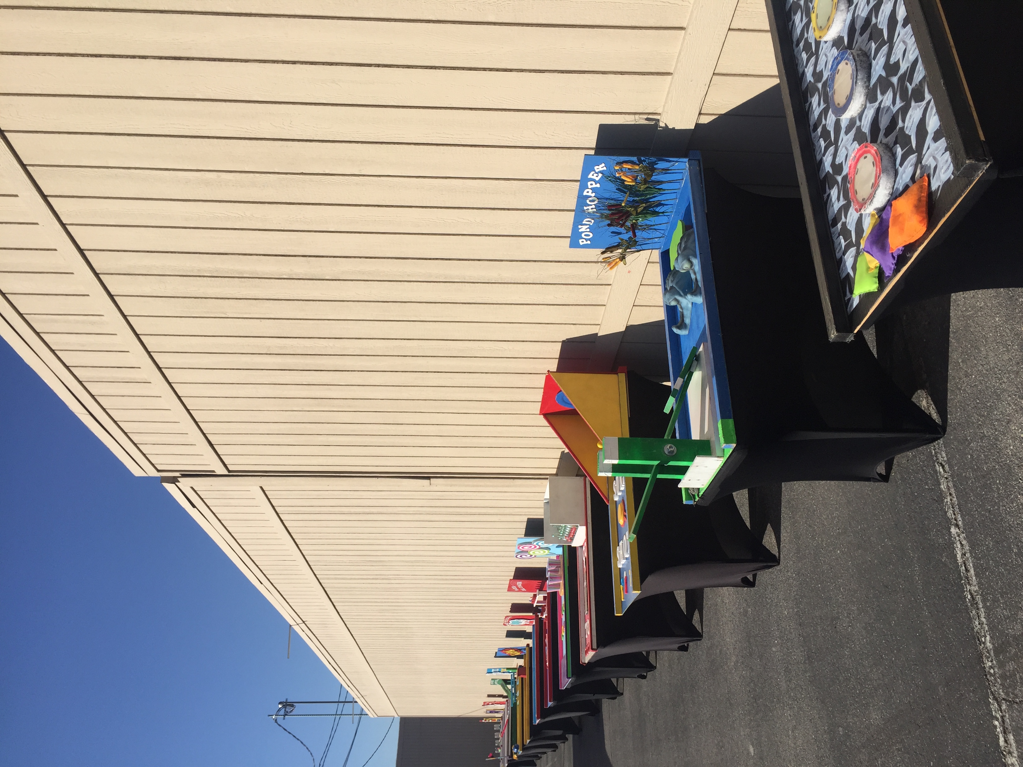 Outdoor lineup of tabletop carnival games, including Pond Hopper and toss challenges, representing interactive game entertainment by The Game Guy in the Louisville area.