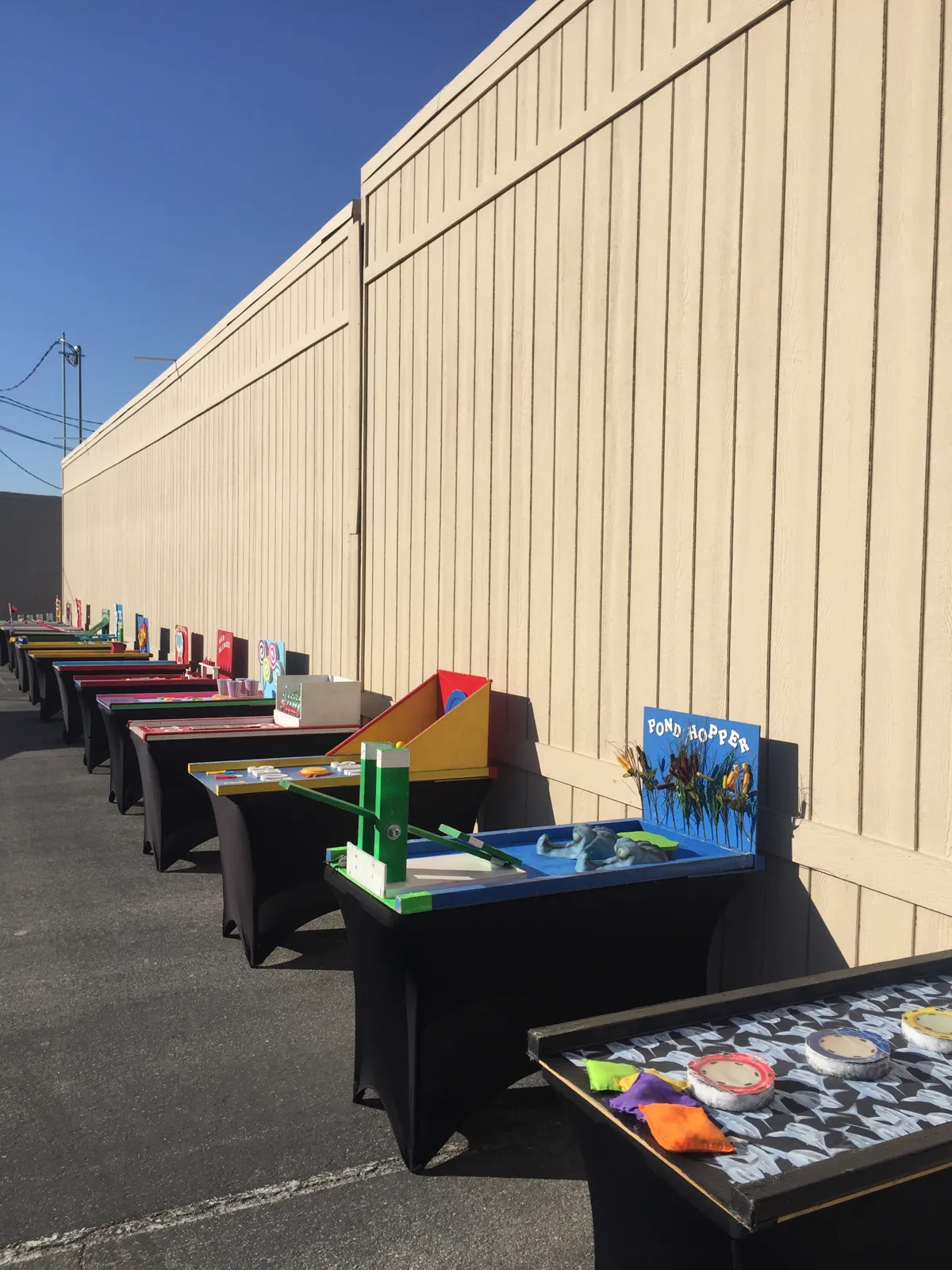 Collection of tabletop carnival games and toss challenges set up outdoors, illustrating game inventory for an event rental business
