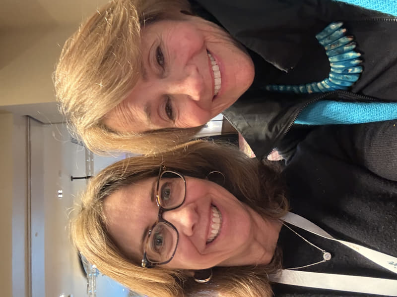 Melissa smiling alongside Lynne Twist, author of The Soul of Money, at a conference event focused on money mindset and financial well-being.